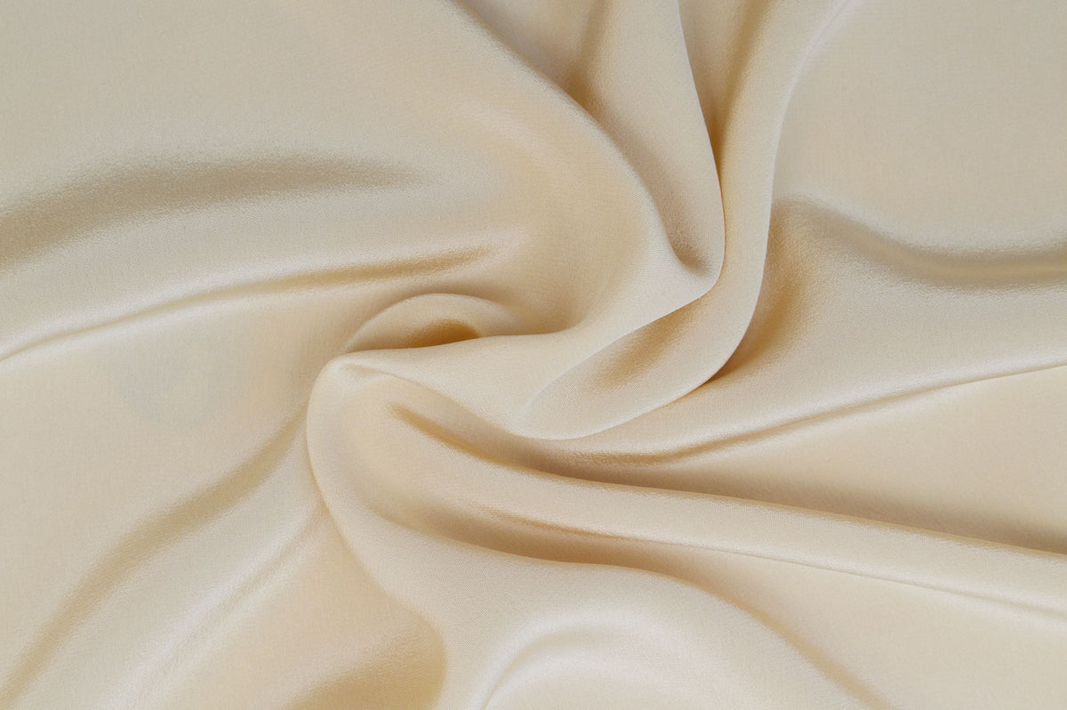 Soft folds of cream silk fabric